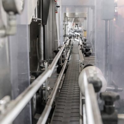 Industrial bottling machine at modern wine factory in Italy, close up.  Automatic conveyor line for wine-producing